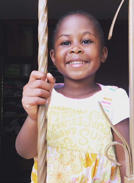 A photo of a beautiful young girl from Hope House Babies Home smiling into the camera